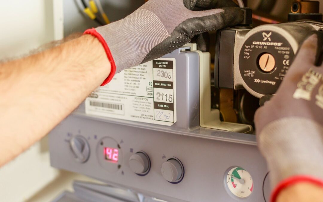 boiler maintenance in michigan person with gloves maintaining a boiler pr HVAC system