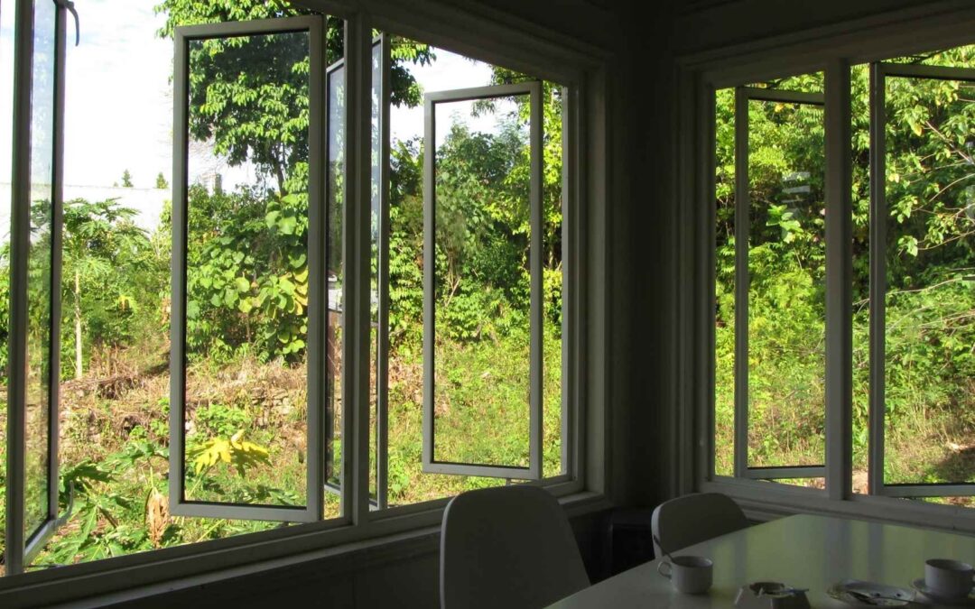 paneled window sections open to let air into the white dining room set-up